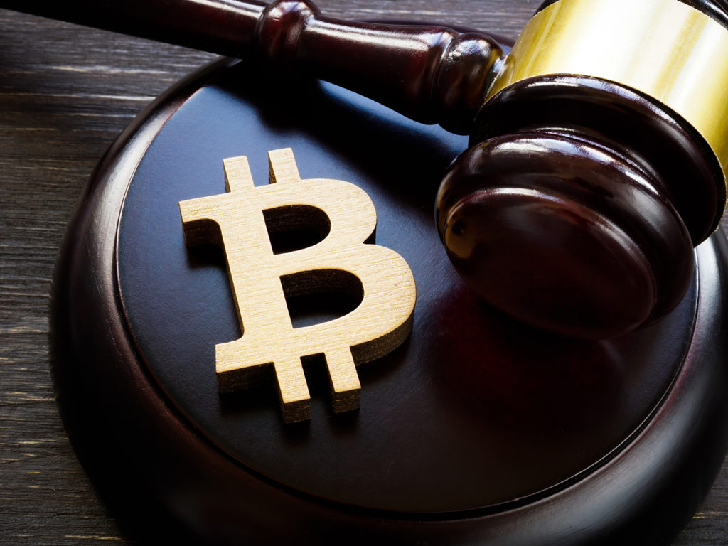 Bitcoin symbol and gavel to regulate cryptocurrencies market.