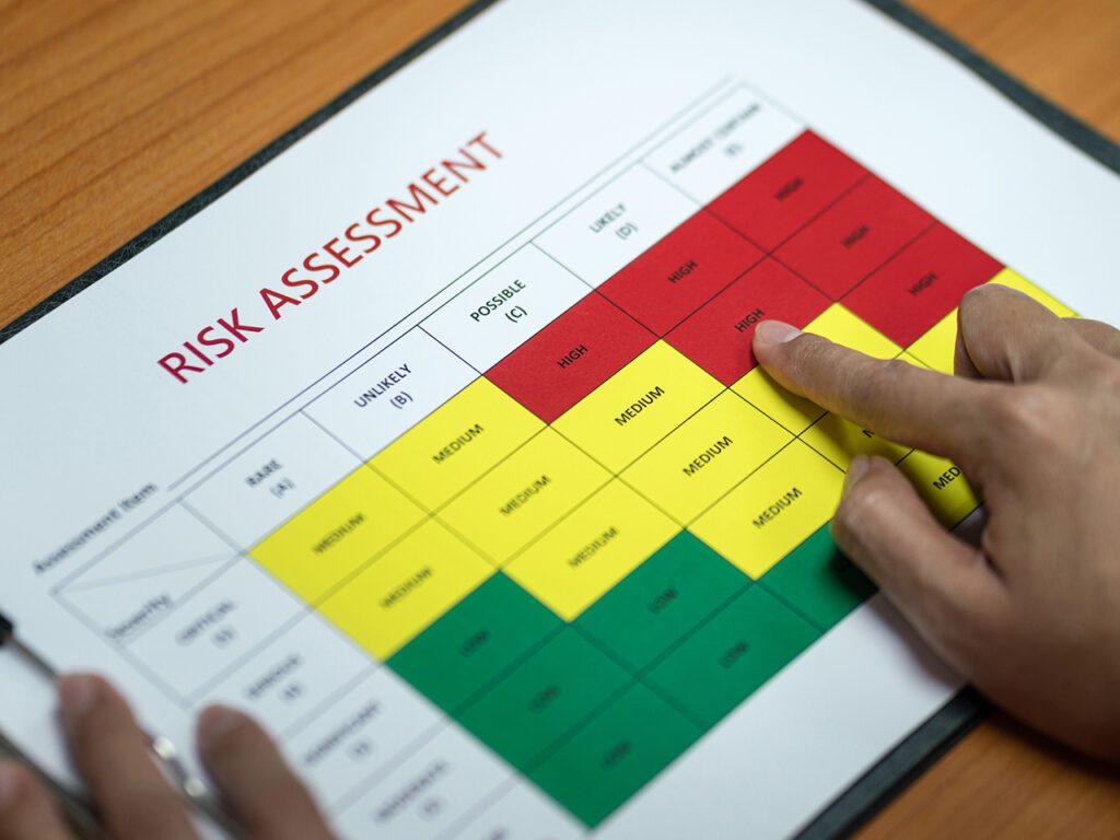 Action of a manager is identify the risk assessment matrix at "High" level. Business and industrial working scene photo.