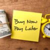 Banknotes,clock and sticky note with the word Buy Now Pay Later.